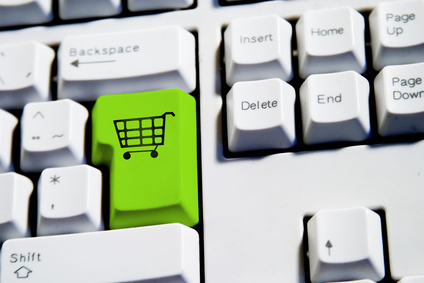 Computer Keyboard from a desktop computer with the enter key highlighted in green with a large shopping cart on it